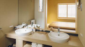 A modern bathroom with two sinks, a large mirror, and a window providing natural light.