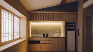 Una cocina compacta con armarios de madera, microondas integrado y un refrigerador.