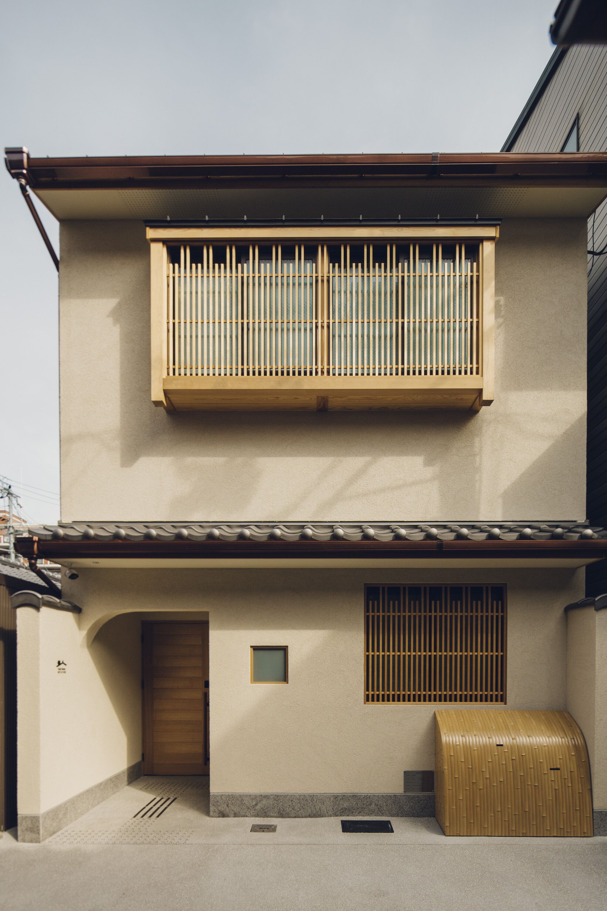 A traditional Japanese building with a wooden balcony, a sliding door, and a small window.