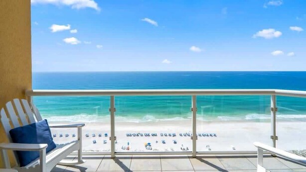 Een balkon met uitzicht op een strand en zee.