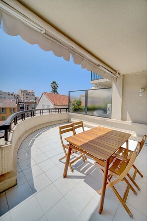 Enjoy a balcony with a table and chairs, offering a view of the surrounding buildings.
