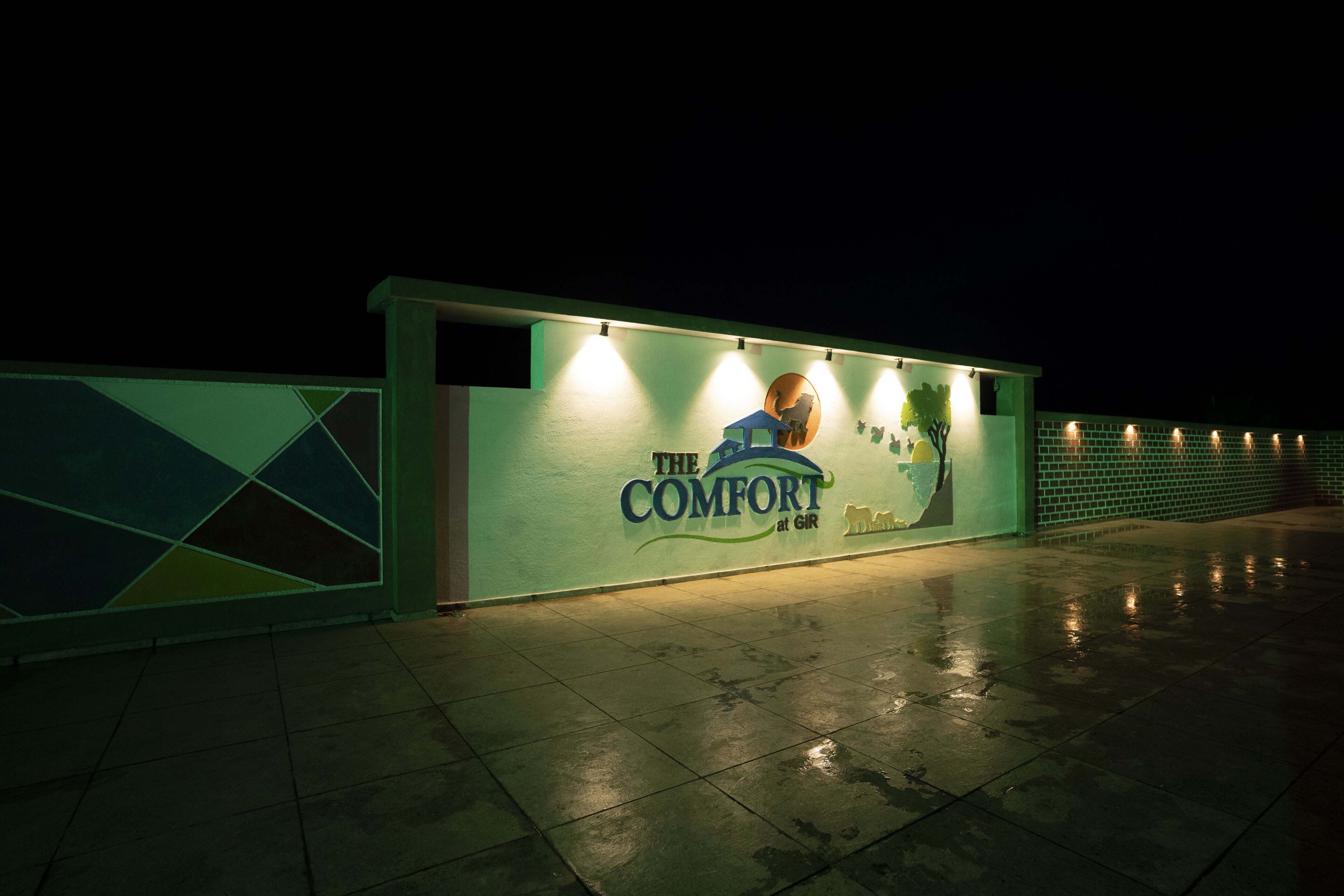 Vista nocturna de un edificio con un letrero que dice 'The Comfort at GIR'.