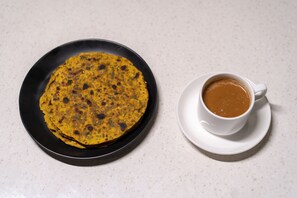 A plate of food and a cup of coffee on a table.