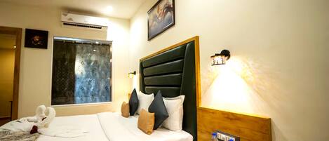Une chambre d’hôtel avec un lit, une table de chevet avec une lampe, un téléphone et une bouteille d’eau.