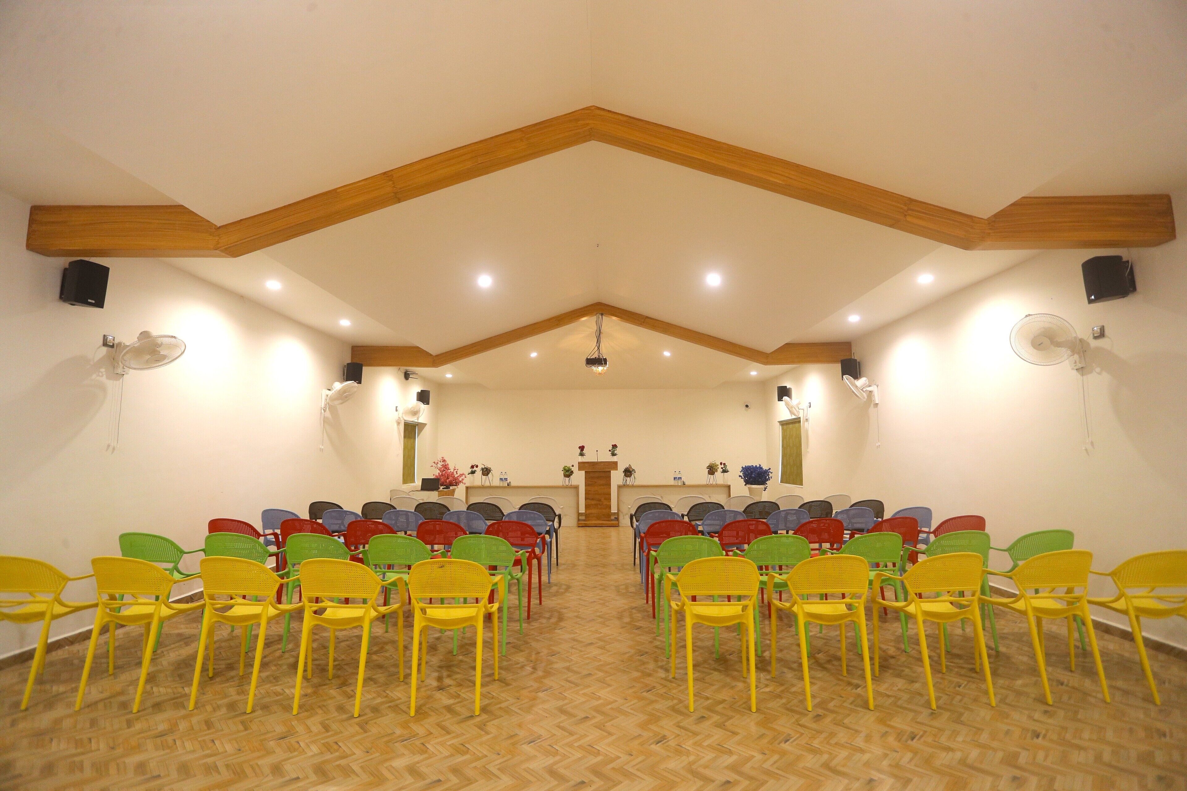 Une salle de conférence dotée d’un plafond en bois et d’un parquet à motifs en chevrons.