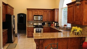 A kitchen with wooden cabinets, a granite countertop, a stainless steel refrigerator, a microwave, and a stove. - New Fresh Water Single Level home 2.3 miles to Mayo Clinic, Kierland, WestWorld (Scottsdale)