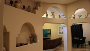 A spacious living area with a brown sofa, a dining table with chairs, and a kitchen area with a stove. - New Fresh Water Single Level home 2.3 miles to Mayo Clinic, Kierland, WestWorld (Scottsdale)