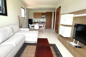 Un salon moderne avec un canapé, une table à manger et un téléviseur.