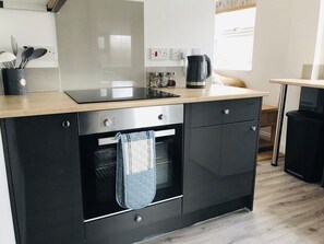 A modern kitchen with a black countertop, stainless steel appliances, and a window providing natural light. - Character Town Centre ,1 Bed Flat, Boston (Boston)