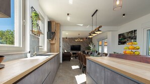 Una cucina moderna con isola centrale, elettrodomestici integrati e un'ampia finestra che garantisce luce naturale.