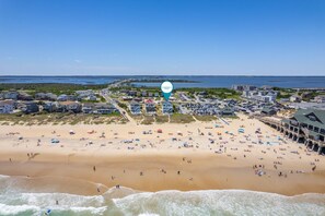 A coastal town with a beach, buildings, and a clear sky.