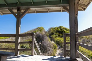 Une terrasse en bois offrant une vue sur une colline et un ciel dégagé.