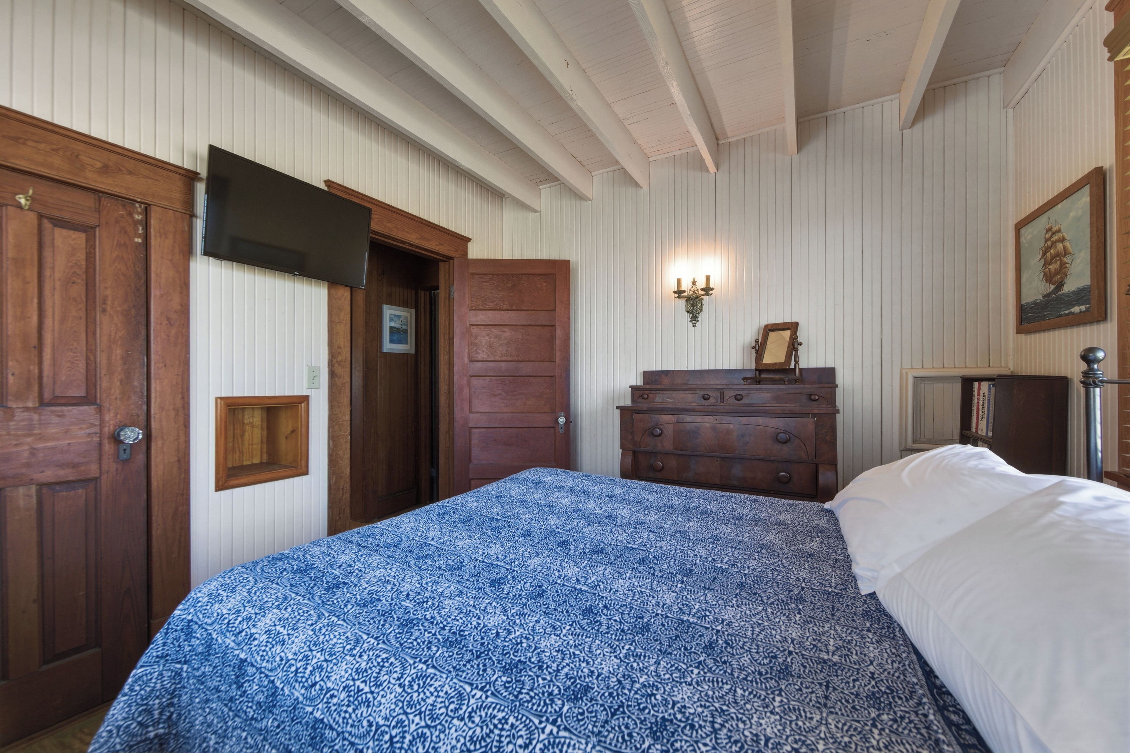 Une chambre à coucher avec un lit, une armoire en bois et une commode.