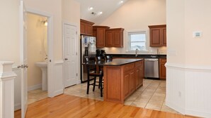 Una cocina con armarios de madera, una isla central y un lavavajillas integrado.