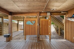 A wooden structure with a whale-shaped door, a bench, and a trash bin.