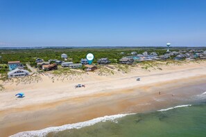 A coastal residential area with houses, a beach, and a water tower. - L'il Seabreeze-Oceanfront, ocean views, awesome sunrises, steps to the beach! (Nags Head)