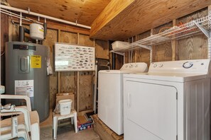 A laundry room with a water heater, a washing machine, and a dryer. - L'il Seabreeze-Oceanfront, ocean views, awesome sunrises, steps to the beach! (Nags Head)