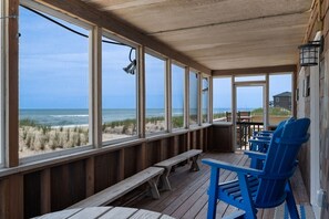 A wooden deck with a view of the beach and ocean. There are benches and chairs along the deck. - L'il Seabreeze-Oceanfront, ocean views, awesome sunrises, steps to the beach! (Nags Head)