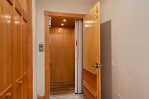 Puerta de madera con un panel de control y puerta corrediza vertical.