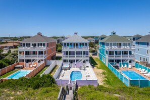 A resort with multiple buildings, outdoor pools, and a clear view of the surrounding area.