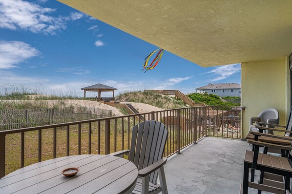 Un balcon avec vue sur la plage, une terrasse en bois et un belvédère.