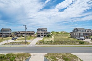 Une zone résidentielle côtière comprenant plusieurs maisons, une route et une plage en arrière-plan.