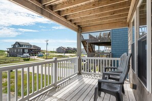 A wooden deck with a view of a house and a road.