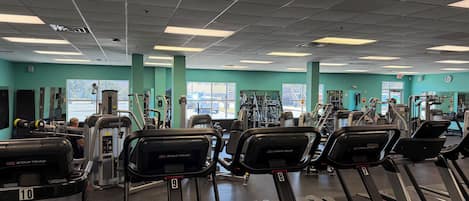 A gym with treadmills, weight machines, and exercise equipment.