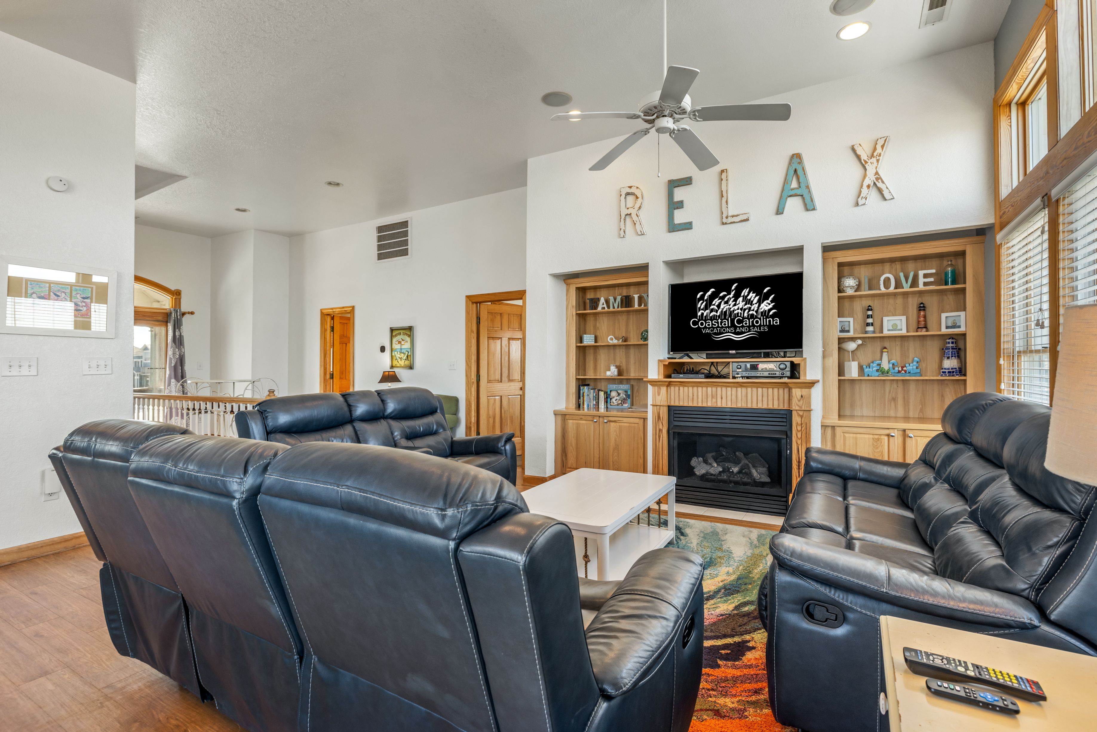 A living room with leather sofas, a fireplace, and a television.