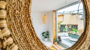 Un interno moderno con un grande specchio che riflette una zona balcone.