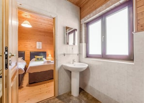 A wooden-paneled bedroom with a bed, a bedside table, and a nightstand.