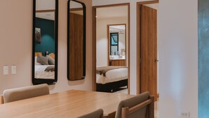 Ein modernes Hotelzimmer mit einem Holztisch, zwei Stühlen und einem großen Spiegel.