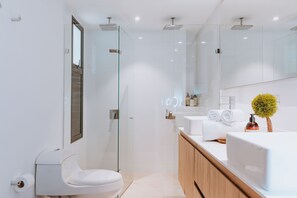 A modern bathroom with a glass shower enclosure, a toilet, a sink with a mirror, and a small potted plant. - Unbelievable! TOP FLOOR! 1,162-square-foot apartment. Reception open 24 hours a day, 7 days a week - 503 (Medellín)