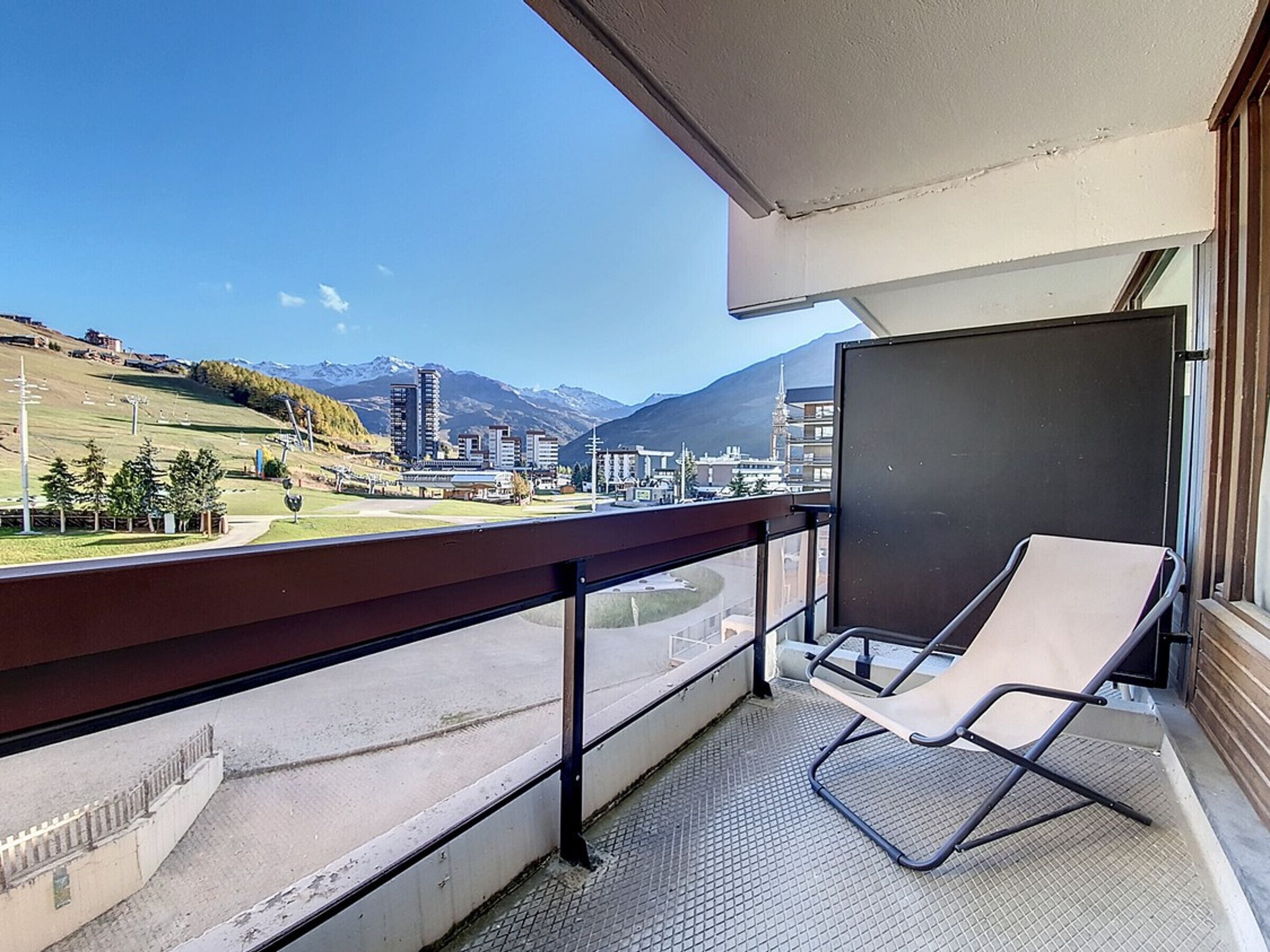 Un balcó amb vista a un paisatge urbà i muntanyes.