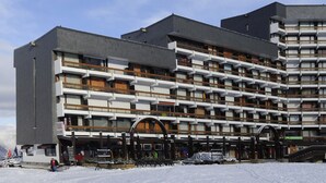 Ein mehrstöckiges Hotel mit modernem architektonischen Design, inklusive Balkonen und einem überdachten Eingangsbereich.