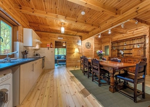 L’intérieur d’un chalet en bois comprend une cuisine, un coin repas et un espace salon confortable.