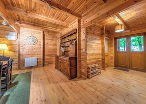 A wooden interior with a dining area, a clock, a radiator, and a door with windows. - Woodland Hawthorn Lodge (Ellesmere)