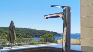 A modern bathroom with a chrome faucet and a view of a mountainous landscape. - Beachfront villa Senses for 12 in Milna (Milna)