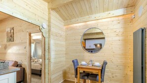 A wooden interior with a dining area, a mirror, and a kitchen visible through the reflection. - 1 bedroom accommodation in Freehay, Cheadle (Freehay, Cheadle)