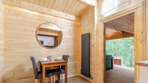 A wooden interior with a dining table, chairs, a mirror, and a view of the outdoors. - 1 bedroom accommodation in Freehay, Cheadle (Freehay, Cheadle)