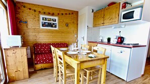 Eine kleine Küche mit Holzausstattung, einer Mikrowelle und einem Kühlschrank.