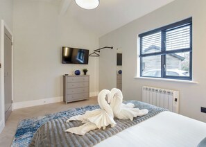 A bedroom with a bed, a dresser, a television, a window, and a radiator. - 2 bedroom accommodation in South Duffield, Nr York (South Duffield, Nr York)