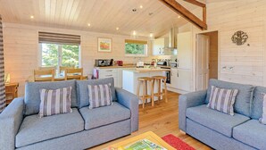 A cozy cabin interior with a living room, kitchen, and dining area. - Luxurious and contemporary lodge with stunning countryside views. (Ashover)