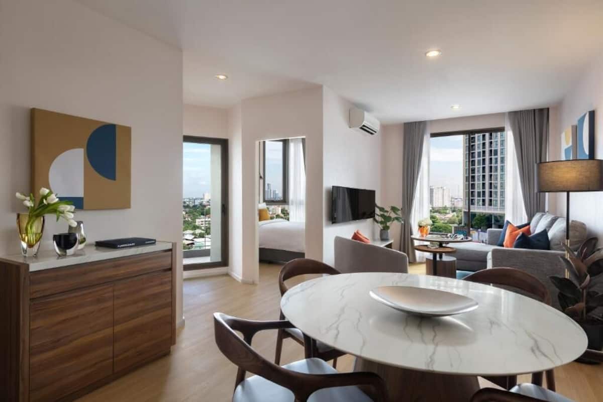 Een moderne hotelkamer met een zithoek, een bank, een televisie en uitzicht op de stad.