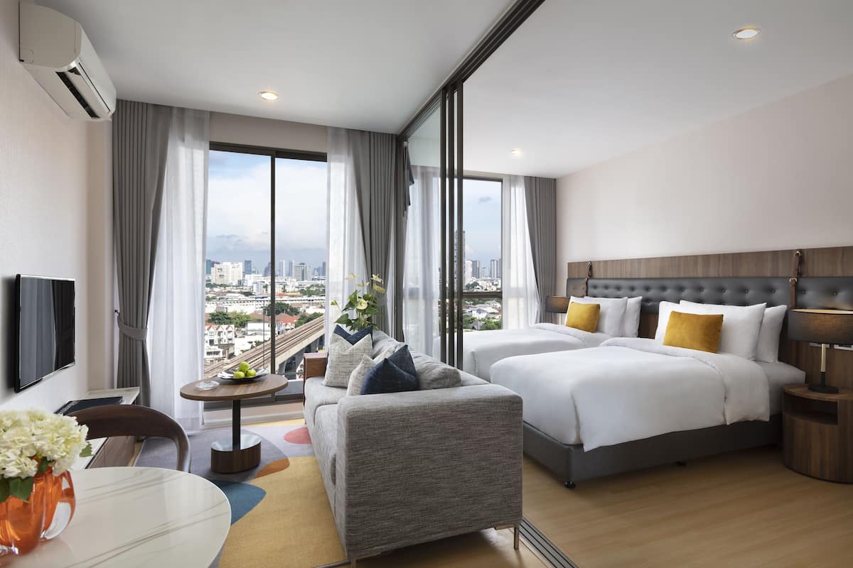 Een moderne hotelkamer met een groot bed, een bank, een tafeltje en een televisie.