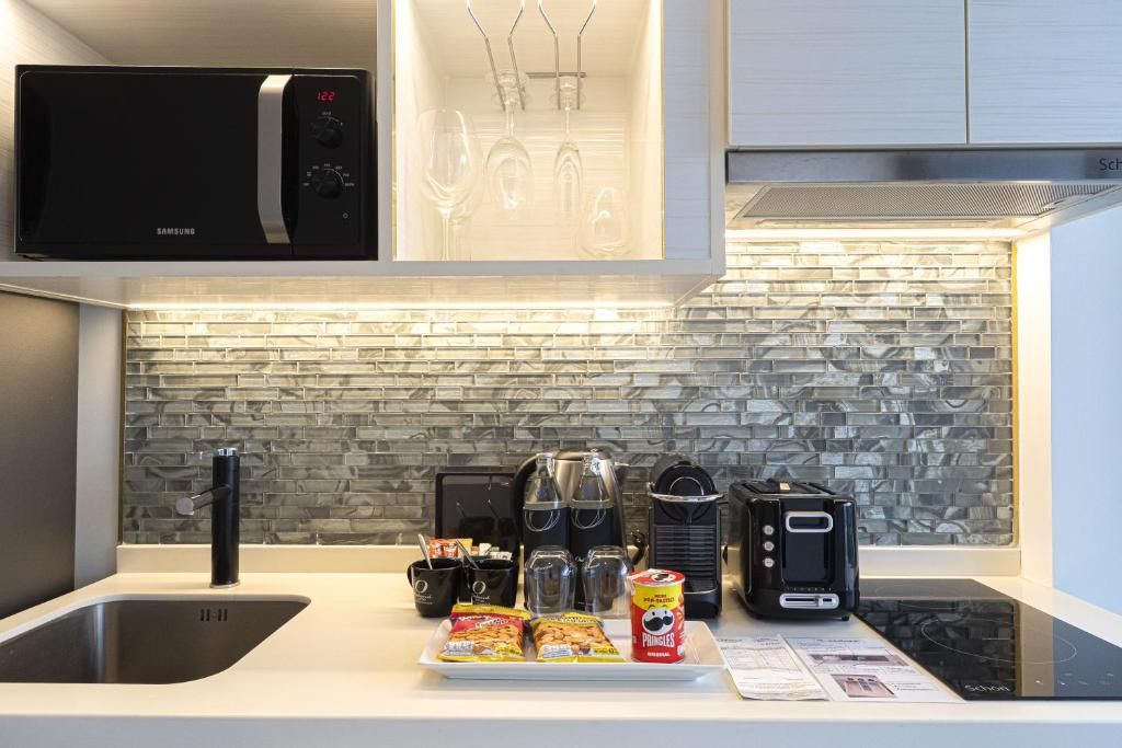 Une cuisine moderne équipée d’un four à micro-ondes, d’un grille-pain et d’une machine à café.