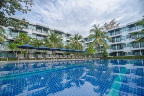 A modern hotel with a swimming pool, lounge chairs, and palm trees. - Holiday Style Ao Nang Beach Resort Krabi (Krabi)