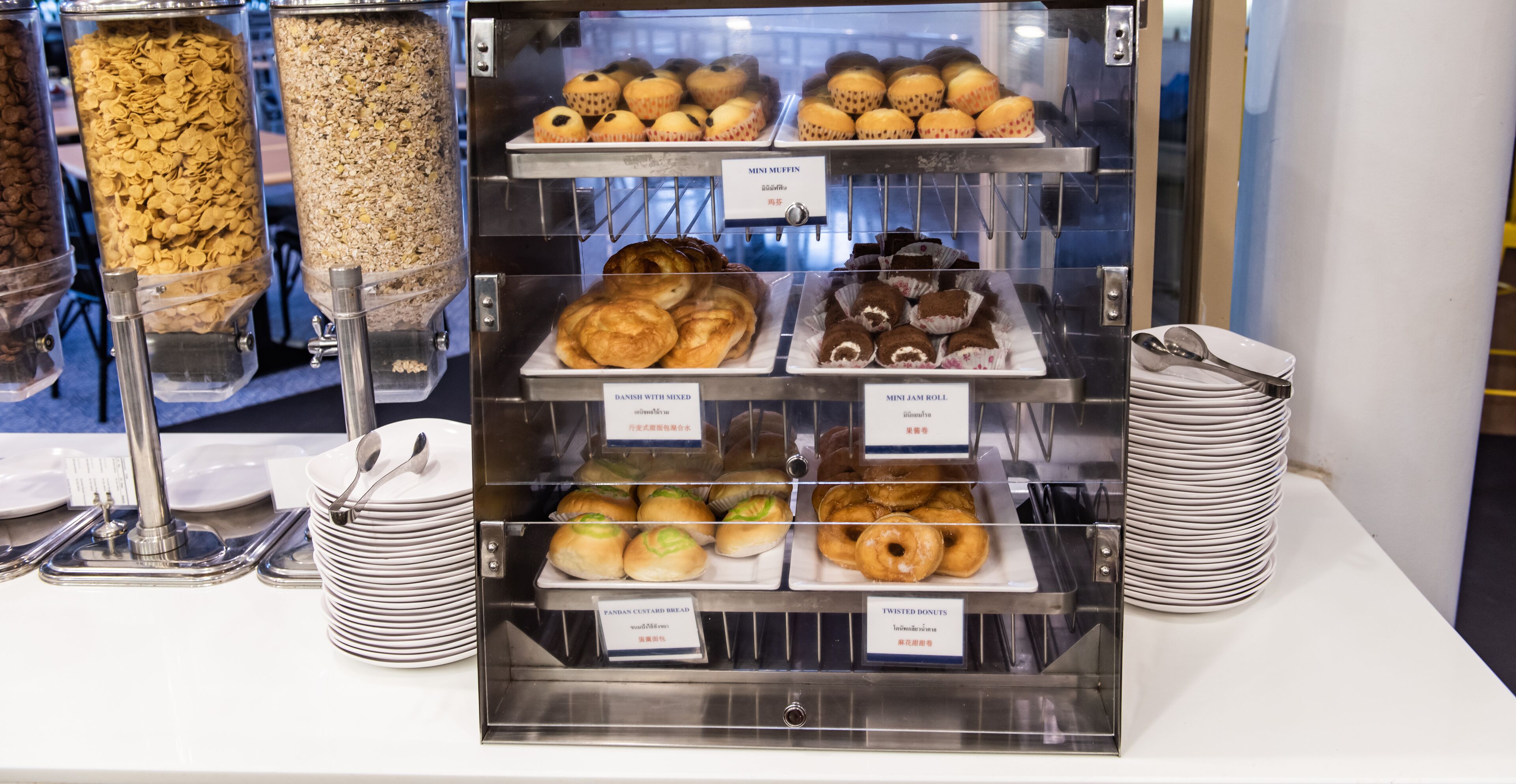 A bakery display with various baked goods like muffins, buns, and pastries.