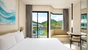Habitación de hotel con cama, escritorio, silla, ventana grande con vista a una piscina y follaje, y un cuadro en la pared.