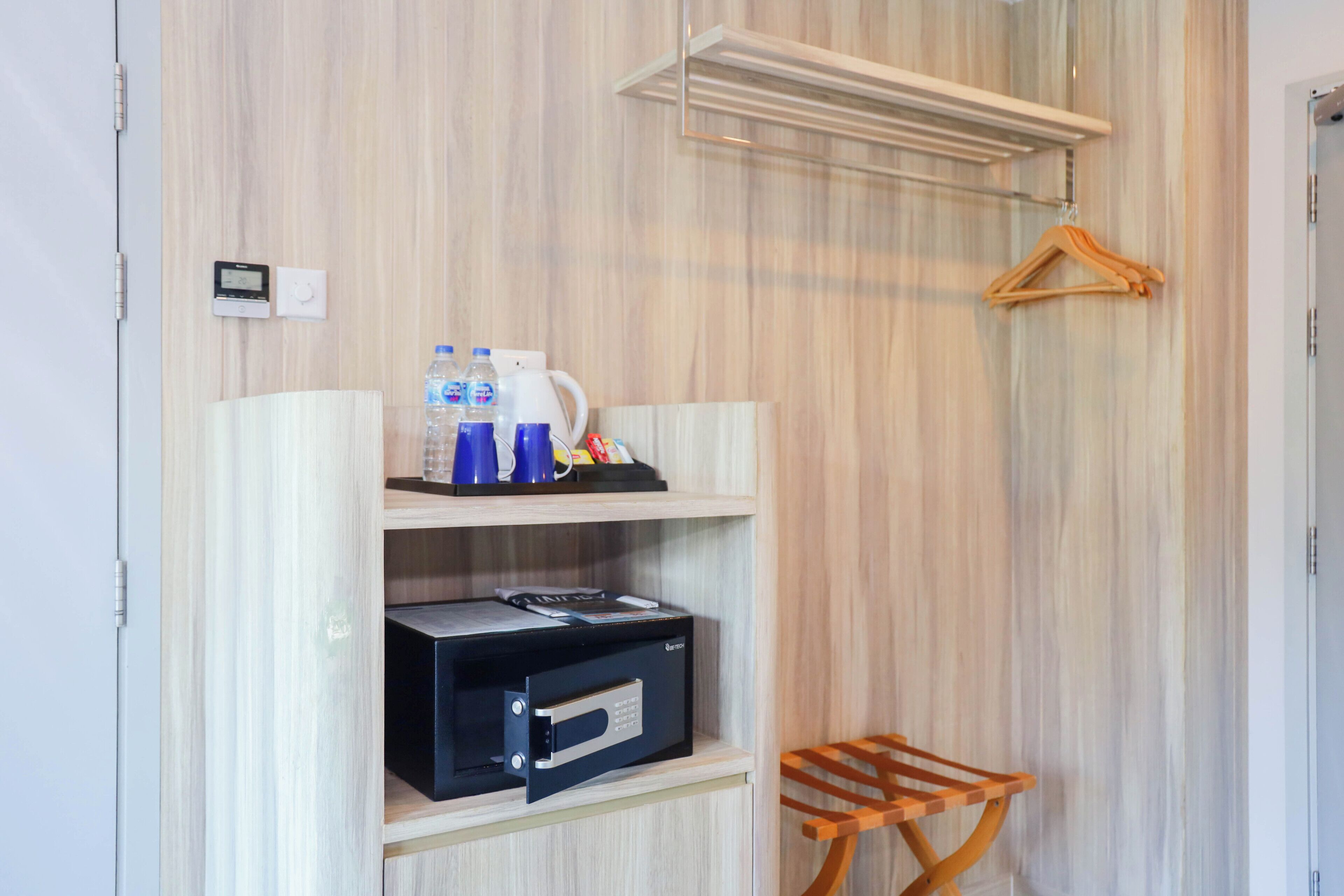 Ein Zimmer mit Holzwand, einem Regal mit Kaffeemaschine, Flaschen und einem schwarzen Gerät.